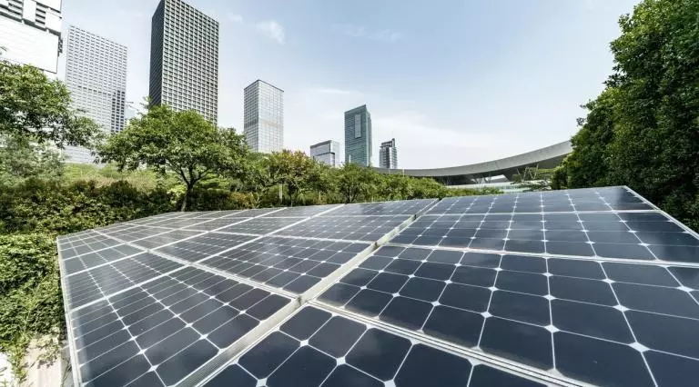 Solar panels with a city skyline behind