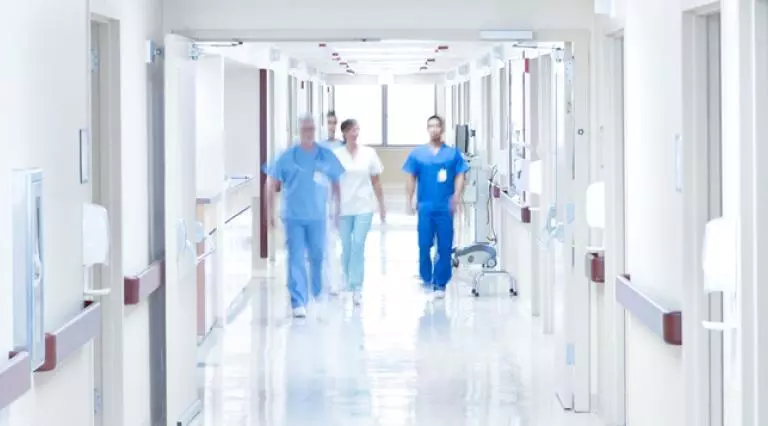 Four healthcare professionals walking down corridor